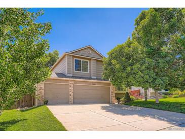 Charming two-story home features a three-car garage, mature trees, and a well-manicured lawn at 5534 S Wenatchee St, Aurora, CO 80015