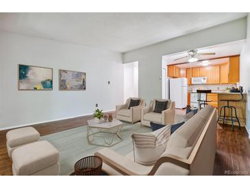 Cozy living room with wood floors, and furniture leading into an updated kitchen at 9385 E Center Ave # 1D, Denver, CO 80247