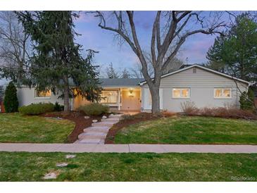 Charming single-story home featuring a brick facade, a welcoming front porch, and mature trees in the landscaped yard at 3206 S Clayton St, Denver, CO 80210