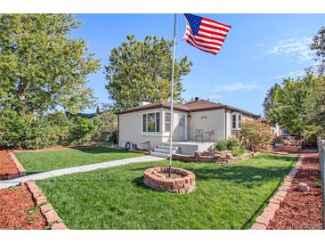 Charming home featuring a manicured lawn, brick accents, and a prominent American flag at 3790 W 54Th Ave, Denver, CO 80221