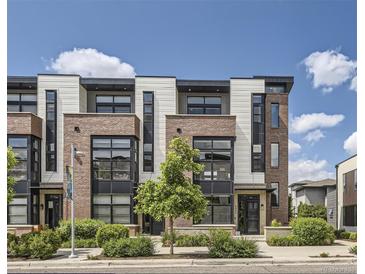 Modern townhome featuring brick and siding with large windows and manicured landscaping at 6849 E Lowry Blvd, Denver, CO 80230