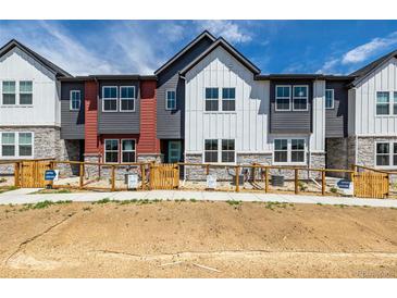 Charming townhomes with modern exteriors, fenced yards, and welcoming open house signs at 2887 E 103Rd Dr, Thornton, CO 80229