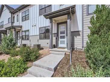 Charming townhouse featuring a covered front entry with well-manicured landscaping at 7987 Yampa River Ave, Littleton, CO 80125