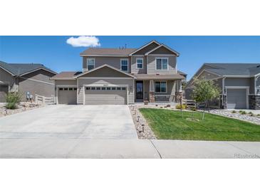 Charming two-story home with a three car garage, well-manicured lawn, and neutral-toned exterior at 6065 Clover Ridge Cir, Castle Rock, CO 80104