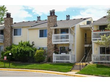 Inviting two-story condo with double balcony, stone chimney, and well-maintained lawn at 8555 Fairmount Dr # C202, Denver, CO 80247