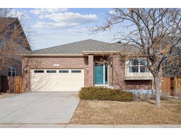 Brick ranch home with two-car garage and landscaped yard at 25077 E Canal Pl, Aurora, CO 80018