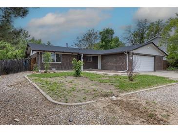 Charming single-story brick home featuring an attached garage, and fresh landscaping at 7042 W 76Th Ave, Arvada, CO 80003