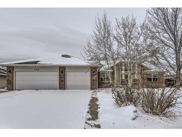 Brick house with a two-car garage and a partially snow covered front yard at 646 N 13Th Ave, Brighton, CO 80601