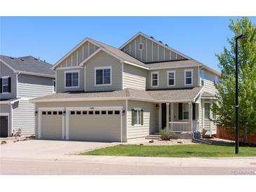 Charming two-story home with a three car garage and landscaped front yard on a sunny day at 1382 Raindrop Way, Castle Rock, CO 80109