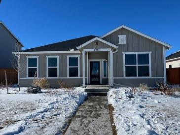 Gray house with white trim and a two-car garage, snow on the ground at 2981 Pershing Street, Strasburg, CO 80136