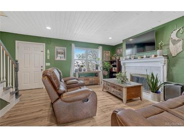 Inviting living room with a fireplace, wood floors, and modern furnishings at 3614 W Radcliff Ave, Denver, CO 80236