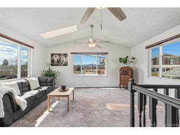 Bright living room with vaulted ceilings, lots of natural light, and mountain views at 6190 Garrison St, Arvada, CO 80004