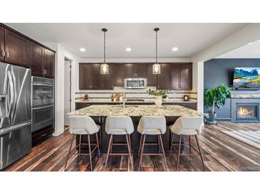 Modern kitchen featuring a large island with seating and stainless steel appliances at 7875 S Grand Baker St, Aurora, CO 80016