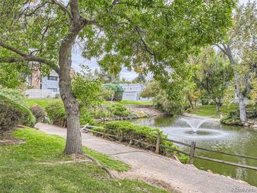 Peaceful community pond with walking path and fountain at 2795 S Lansing Way, Aurora, CO 80014