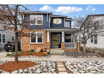 Charming two-story home with brick accents, a covered front porch, and beautifully landscaped yard at 2949 Emporia Ct, Denver, CO 80238