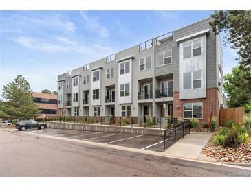 Modern townhome complex with gray siding, brick accents, and rooftop terraces, offering contemporary living at 8711 E Hampden Ave # 22, Denver, CO 80231