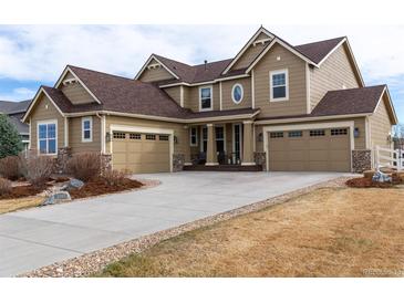 Front exterior of a two-story home with stone accents and three-car garage at 3392 Homestead Dr, Longmont, CO 80504