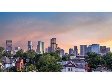 Beautiful downtown skyline view overlooking lush trees and neighborhood buildings with warm sunset in Denver, Colorado at 2721 Curtis St, Denver, CO 80205