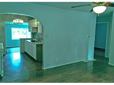 Open living area view into the kitchen with dark hardwood flooring and neutral wall paint at 7960 Oneida St, Commerce City, CO 80022