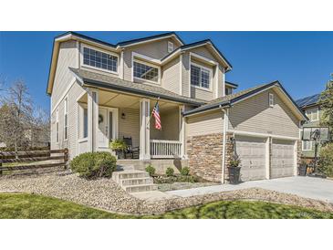 Charming two-story home with a welcoming front porch, stone accents, and a well-maintained lawn at 10487 Panther Trce, Lone Tree, CO 80124
