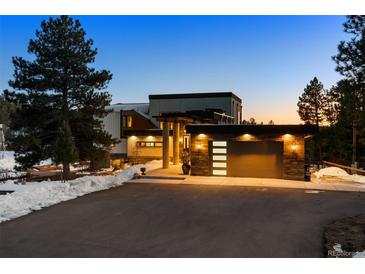 Stunning modern home with sleek architectural lines, a porte-cochere, and a well-lit two-car garage at 367 Sandy Hollow Trl, Franktown, CO 80116