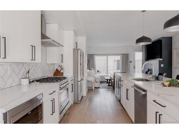 Bright, open kitchen featuring white cabinets, stainless steel appliances, and a quartz countertop island at 1322 Raleigh St, Denver, CO 80204