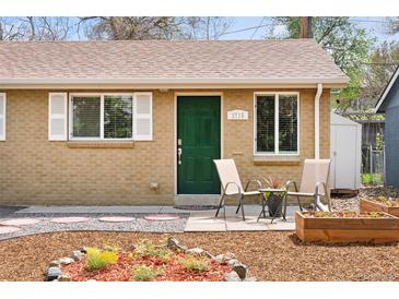 Charming brick home featuring a well-maintained front yard with planters and a cozy seating area near the entrance at 3715 Wolff St, Denver, CO 80212