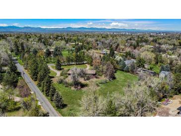 Scenic aerial view of a home nestled among mature trees with mountain views in the distance at 4480 S Franklin St, Cherry Hills Village, CO 80113