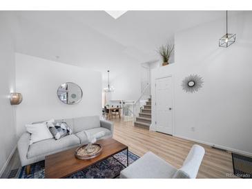 Bright living room featuring an open layout, wood floors, and staircase to the second floor at 7072 Palisade Dr, Highlands Ranch, CO 80130