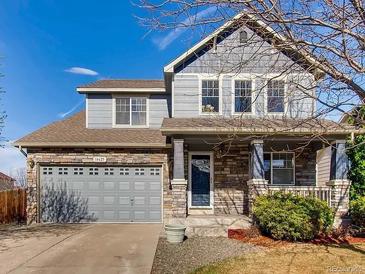 Charming two-story home featuring stone accents and a well-manicured front yard on a sunny day at 14625 Vine St, Thornton, CO 80602