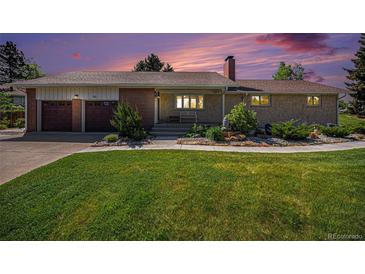 Charming single-story home with brick and stone accents, lush lawn, and a two-car garage at 90 Ammons St, Lakewood, CO 80226