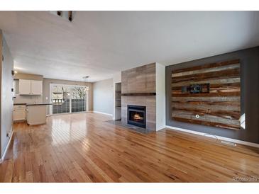 Inviting living room featuring a modern fireplace and wood floors, creating a warm, stylish atmosphere at 1818 S Quebec Way # B15-5, Denver, CO 80231