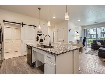 Modern kitchen features granite counters, an island with a sink, and stainless steel appliances at 16841 Askins Loop # 105, Parker, CO 80134