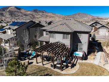 Aerial view of a backyard featuring a patio, pergola, hot tub, and beautiful mountain views at 15798 Weaver Gulch Dr, Morrison, CO 80465