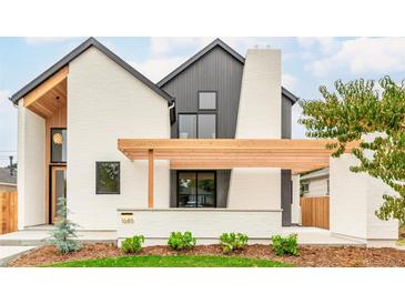 Striking modern home showcasing a light brick facade, wood beam accent, dark trim, and manicured lawn at 1685 S Milwaukee St, Denver, CO 80210