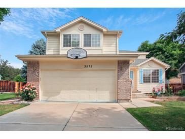 Charming two-story home featuring a two-car garage with a basketball hoop, and manicured landscaping at 3575 W Hamilton Pl, Denver, CO 80236