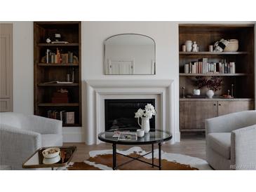 Cozy living room featuring built-in bookshelves, a fireplace, and stylish decor at 4131 Quivas St, Denver, CO 80211