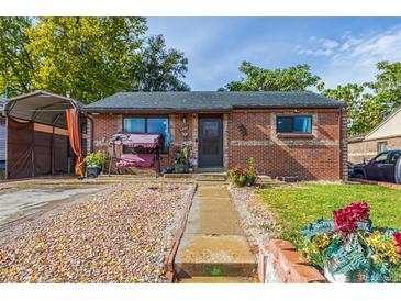 Charming brick home featuring a well-manicured lawn, covered porch, and a cozy swing at 1591 S Zuni St, Denver, CO 80223