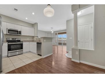 View of the kitchen leading into the living room and dining space at 9568 W San Juan Cir # 203, Littleton, CO 80128