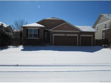 Two-story home featuring brick facade and an attached two-car garage, covered in snow at 25858 E Bayaud Ave, Aurora, CO 80018