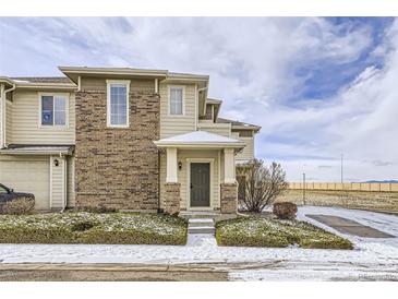 Inviting exterior of a two-story townhouse featuring a brick facade, covered entryway, and manicured landscaping at 13001 Grant Cir # C, Thornton, CO 80241