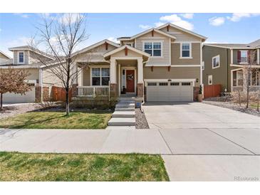 Charming two-story home featuring a covered porch, well-manicured lawn, and an attached two-car garage at 14938 Vienna Cir, Parker, CO 80134