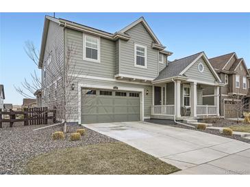 Charming two-story home features a covered front porch, a two-car garage, and manicured landscaping at 946 Compass Dr, Erie, CO 80516