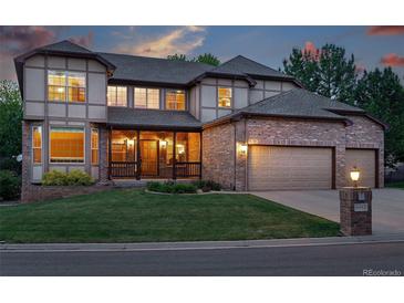 Charming brick and stucco two-story home with a well-manicured lawn and attached two car garage at 5683 Fig Way, Arvada, CO 80002