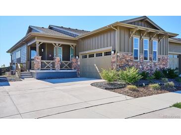 Charming home showcasing a stone and siding exterior with a covered front porch and attached two-car garage at 2012 Sagerock Dr, Castle Pines, CO 80108