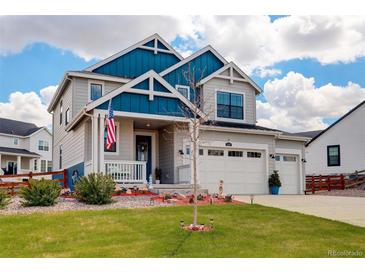 Charming two-story home with blue and gray exterior, landscaped yard, and an attached three car garage at 1256 Elbridge Dr, Elizabeth, CO 80107