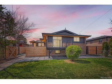 Charming home exterior with a deck, landscaped yard, and wooden fence at 2065 Depew St, Edgewater, CO 80214