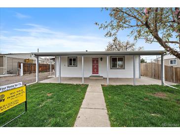 Charming single-story home with a covered porch and a well-maintained front yard at 7460 Krameria Dr, Commerce City, CO 80022