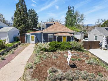 Charming home featuring mature landscaping and a bright yellow front door at 3941 S Elati St, Englewood, CO 80110