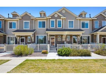 Charming townhome with a well-manicured lawn and white picket fence, offering curb appeal at 16285 W 62Nd Ln # C, Arvada, CO 80403